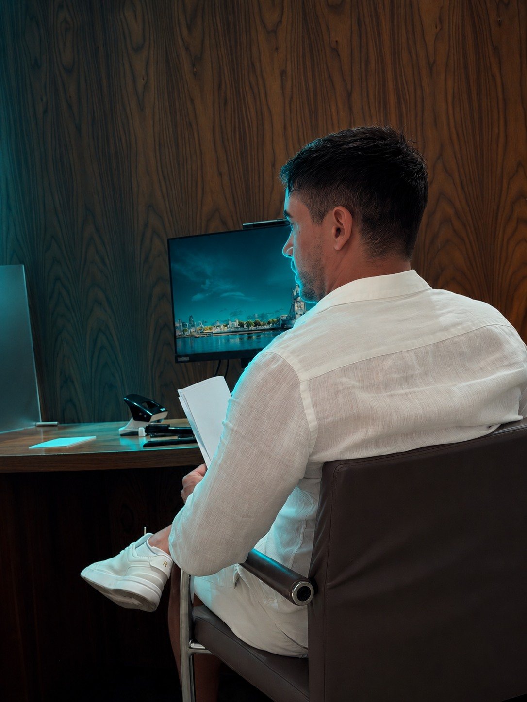 Claudiu at his desk, reading, next to a glowing holographic brain